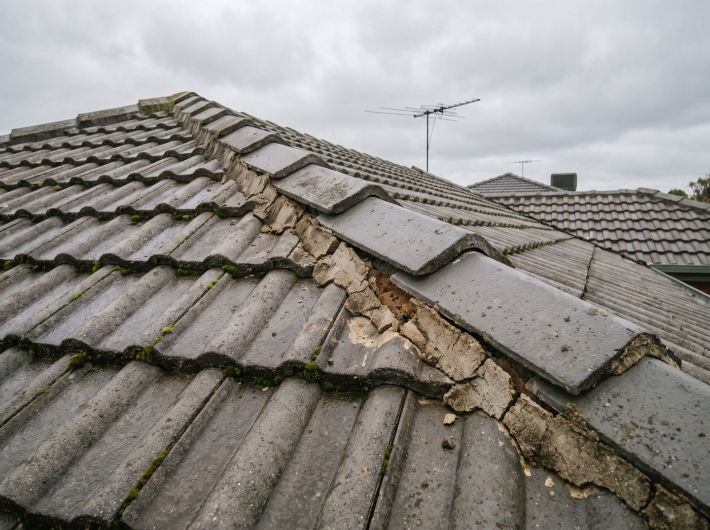Cracked and crumbling mortar under loose ridge capping