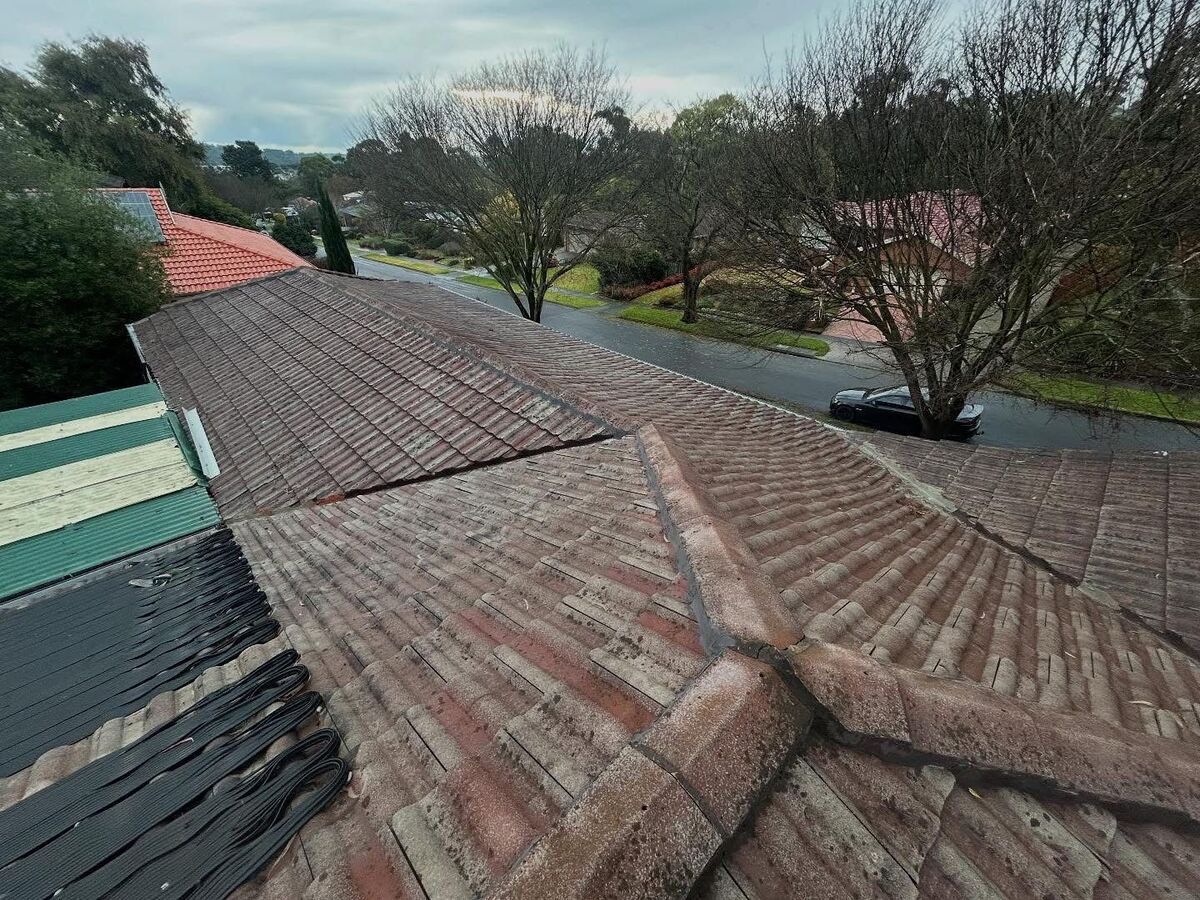 A weathered cement tile roof before we restored it