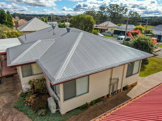 A grey corrugated metal roof on a weatherboard home